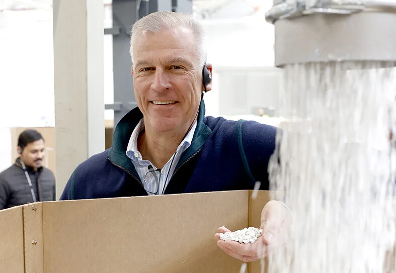 muškarac u ruci drži reciklirane PVC granule