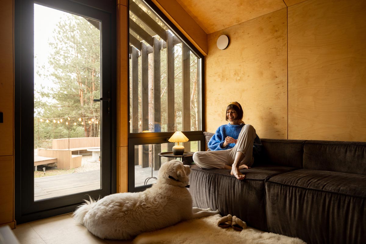 Devojka i pas pored prozora velikih dimenzija