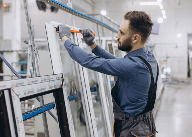 Radnik u industrijskom pogonu za prozore