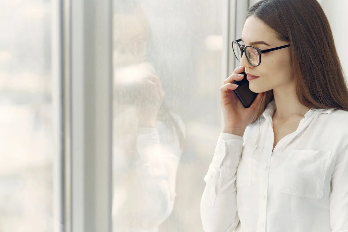 Žena pored prozora telefonra