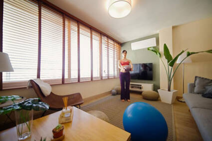 Devojka pored prozora sa zebra zavesama / foto: freepik.com